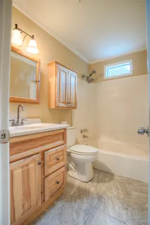 a bathroom with a toilet a sink a mirror a bathtub and vanity