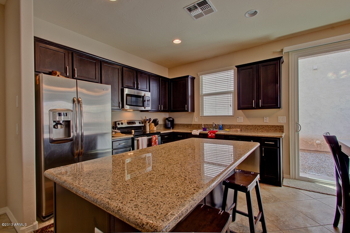 4073 East Tulsa Street Gilbert, AZ 85295 - Photo 11 of 33 a kitchen with a table chairs refrigerator and microwave