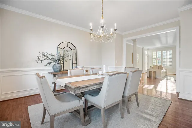 a living room with couches chairs and kitchen view with wooden floor