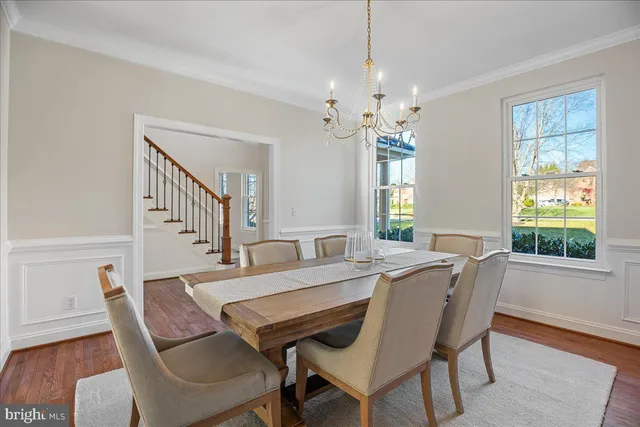a view of a dining room and livingroom with furniture wooden floor a chandelier