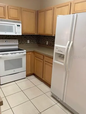 a kitchen with a refrigerator sink and cabinets