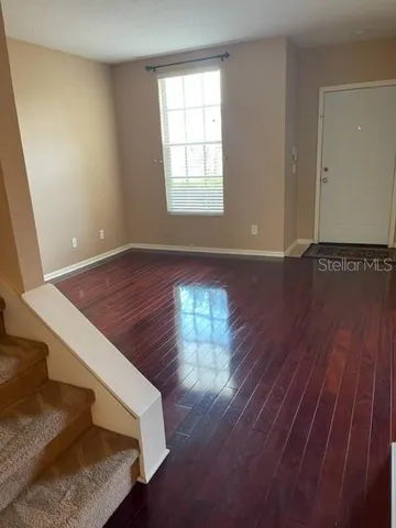 a view of a room with wooden floor and window
