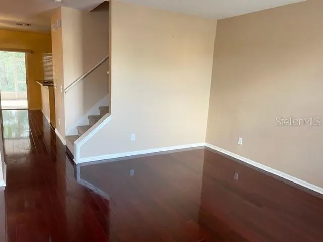 a view of an empty room with wooden floor