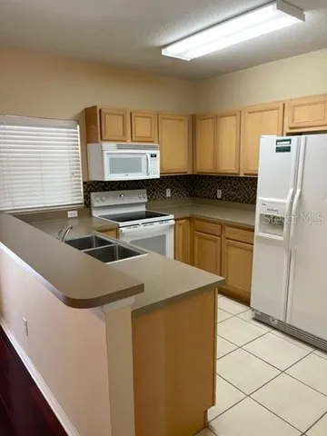 a kitchen with a sink a stove top oven and refrigerator