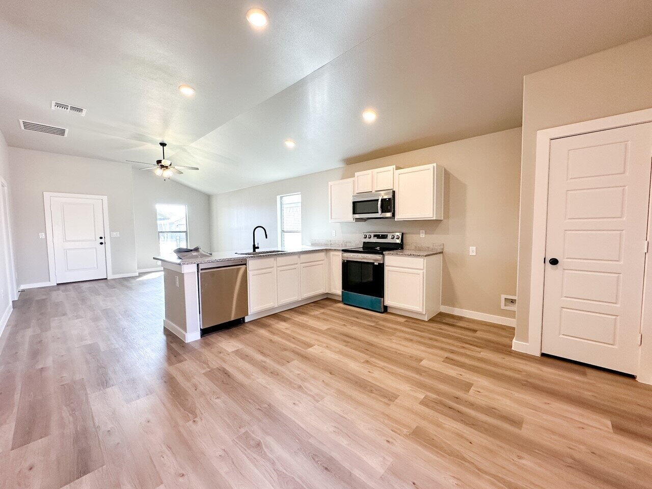 6928 10th Street Lubbock, TX 79416 - Photo 11 of 23 a large kitchen with cabinets and stainless steel appliances