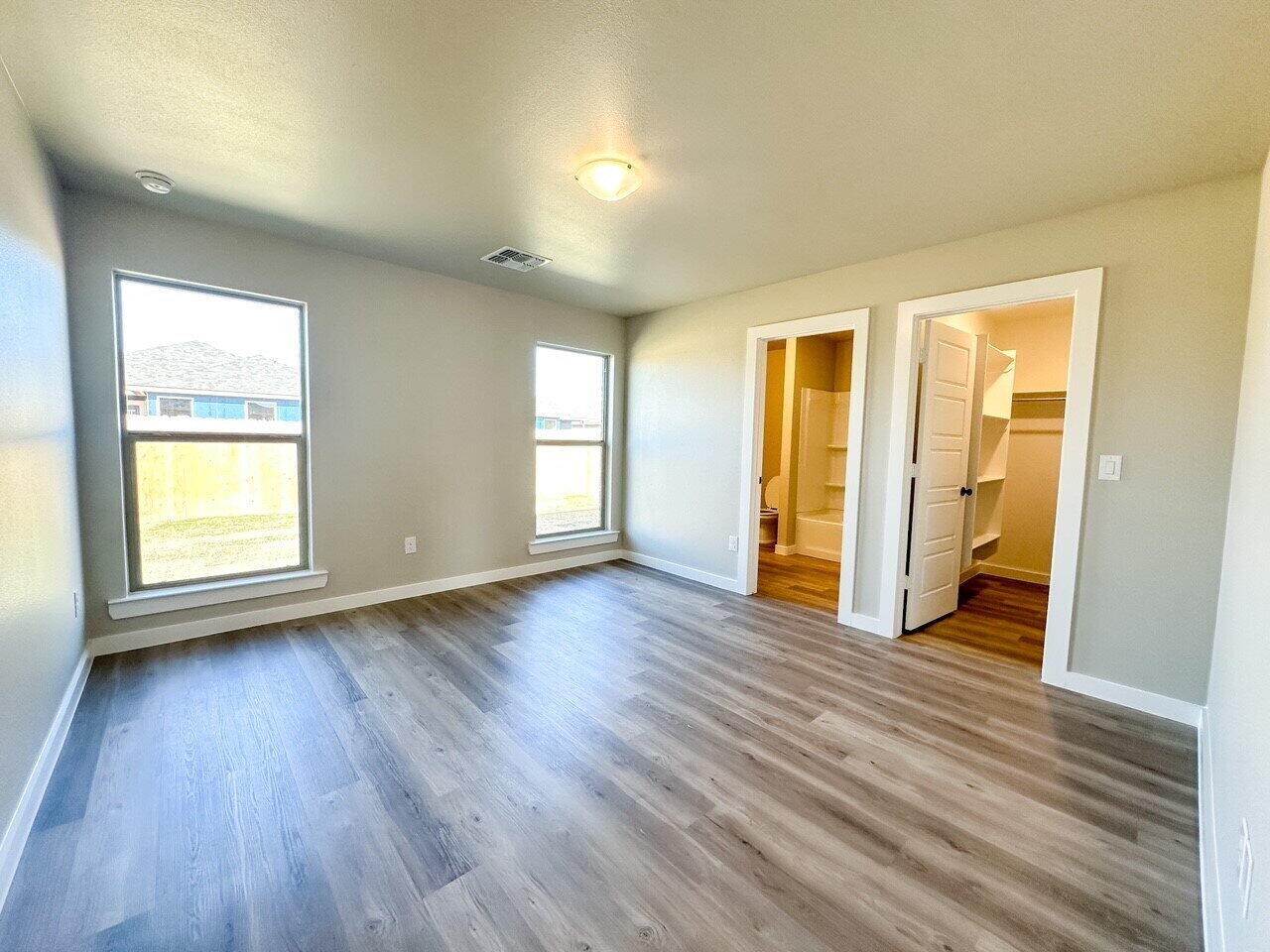 6928 10th Street Lubbock, TX 79416 - Photo 13 of 23 an empty room with wooden floor and windows