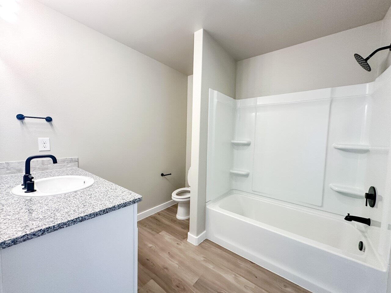 6928 10th Street Lubbock, TX 79416 - Photo 14 of 23 a bathroom with a granite countertop sink a toilet and bathtub