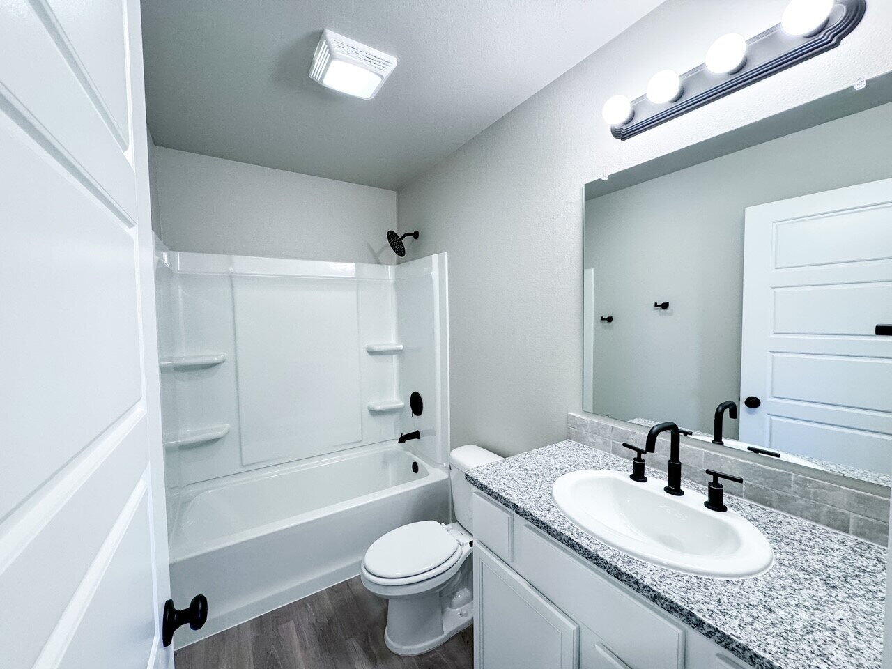 6928 10th Street Lubbock, TX 79416 - Photo 18 of 23 a bathroom with a sink a toilet and a bathtub