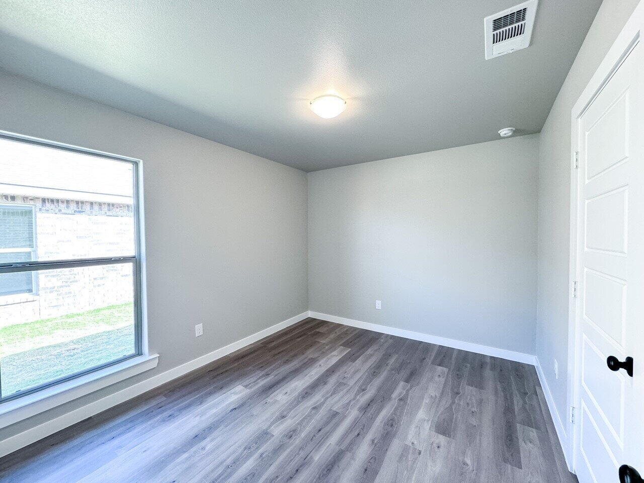 6928 10th Street Lubbock, TX 79416 - Photo 19 of 23 wooden floor in an empty room with a window