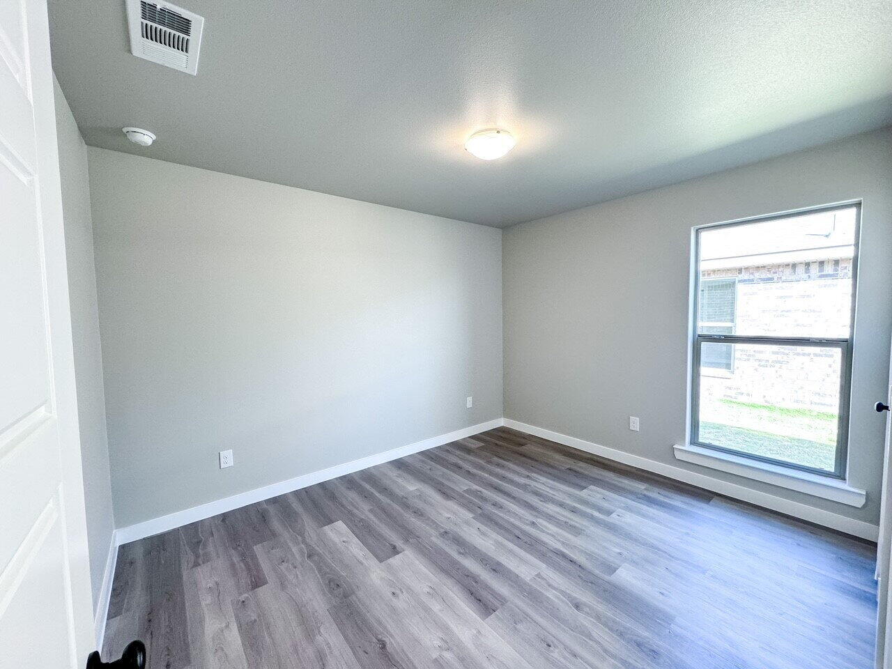 6928 10th Street Lubbock, TX 79416 - Photo 22 of 23 an empty room with wooden floor and windows
