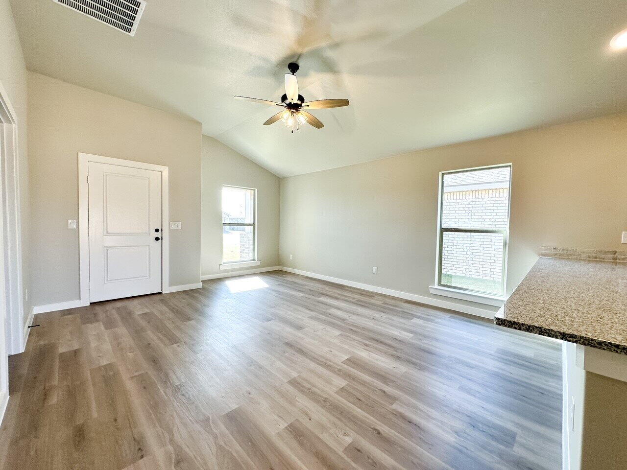 6928 10th Street Lubbock, TX 79416 - Photo 4 of 23 an empty room with wooden floor and windows