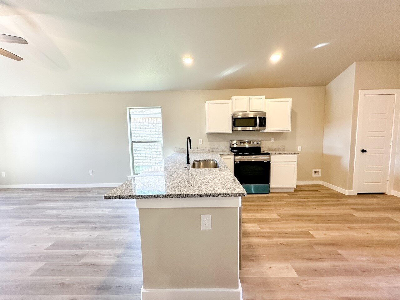 6928 10th Street Lubbock, TX 79416 - Photo 7 of 23 a kitchen with granite countertop a stove and a sink