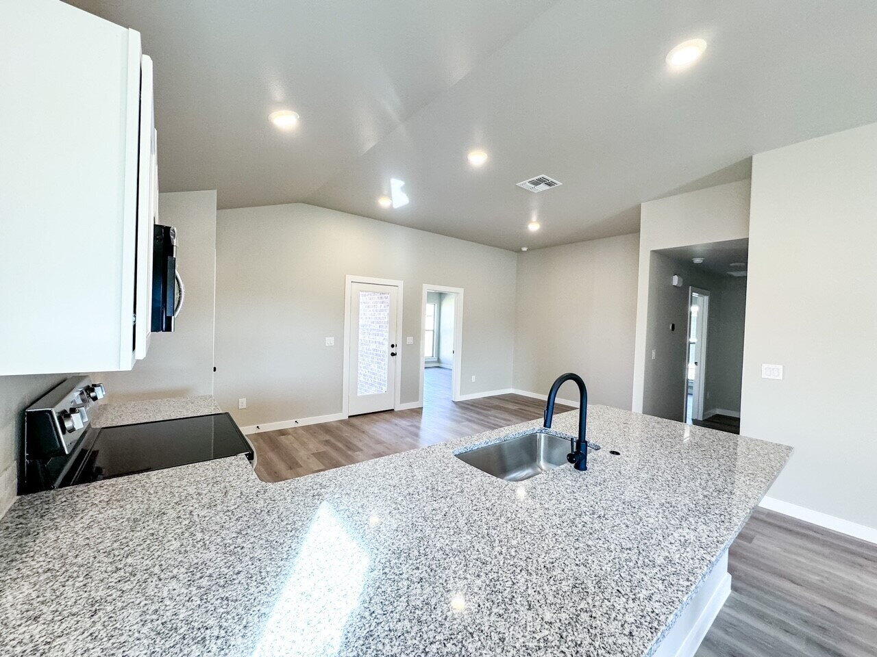 6928 10th Street Lubbock, TX 79416 - Photo 8 of 23 a kitchen with stainless steel appliances granite countertop a sink a refrigerator and a granite counter tops
