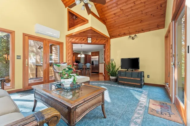 a living room with furniture a flat screen tv and a floor to ceiling window