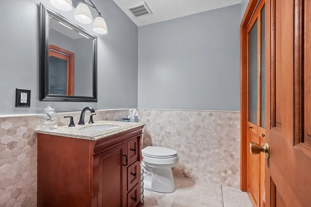 a bathroom with a toilet a sink and a mirror