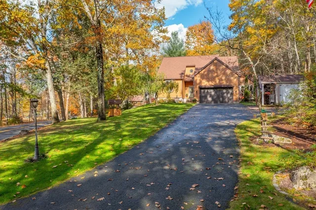 a front view of a house with a yard and tree s