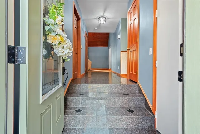 a view of a hallway with wooden floor and stairs