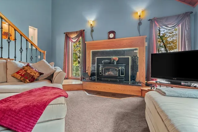 a bedroom with furniture a flat screen tv and a fireplace