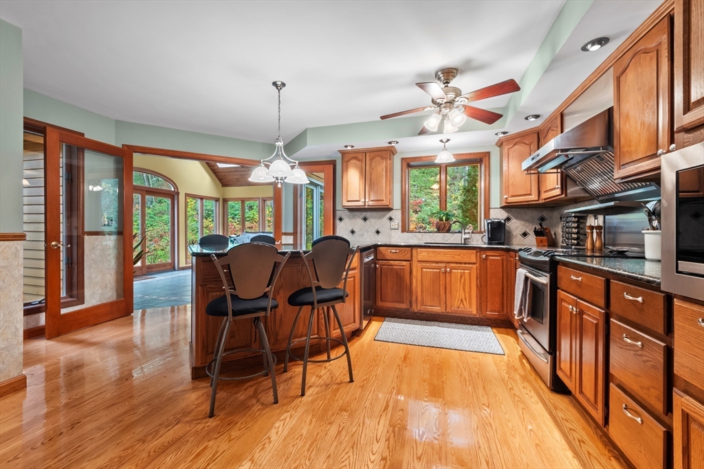 45 North Farms Road Williamsburg, MA 01039 - Photo 9 of 41 a kitchen with stainless steel appliances granite countertop wooden floor dining table and chairs