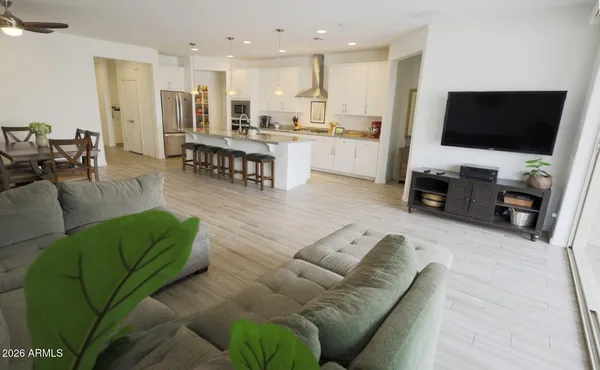a living room with furniture a flat screen tv and a window