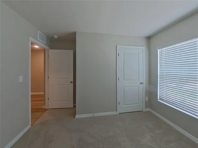 an empty room with closet and windows