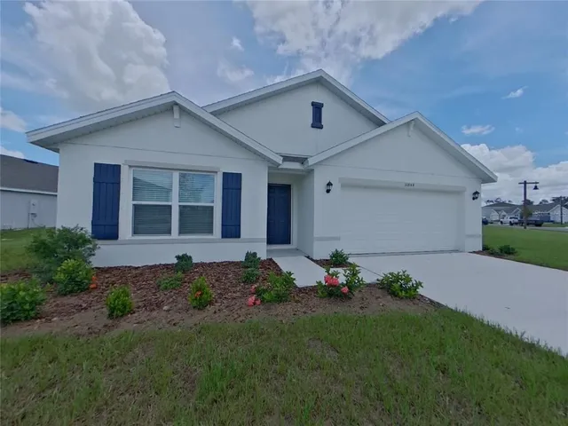a front view of a house with a garden and plants