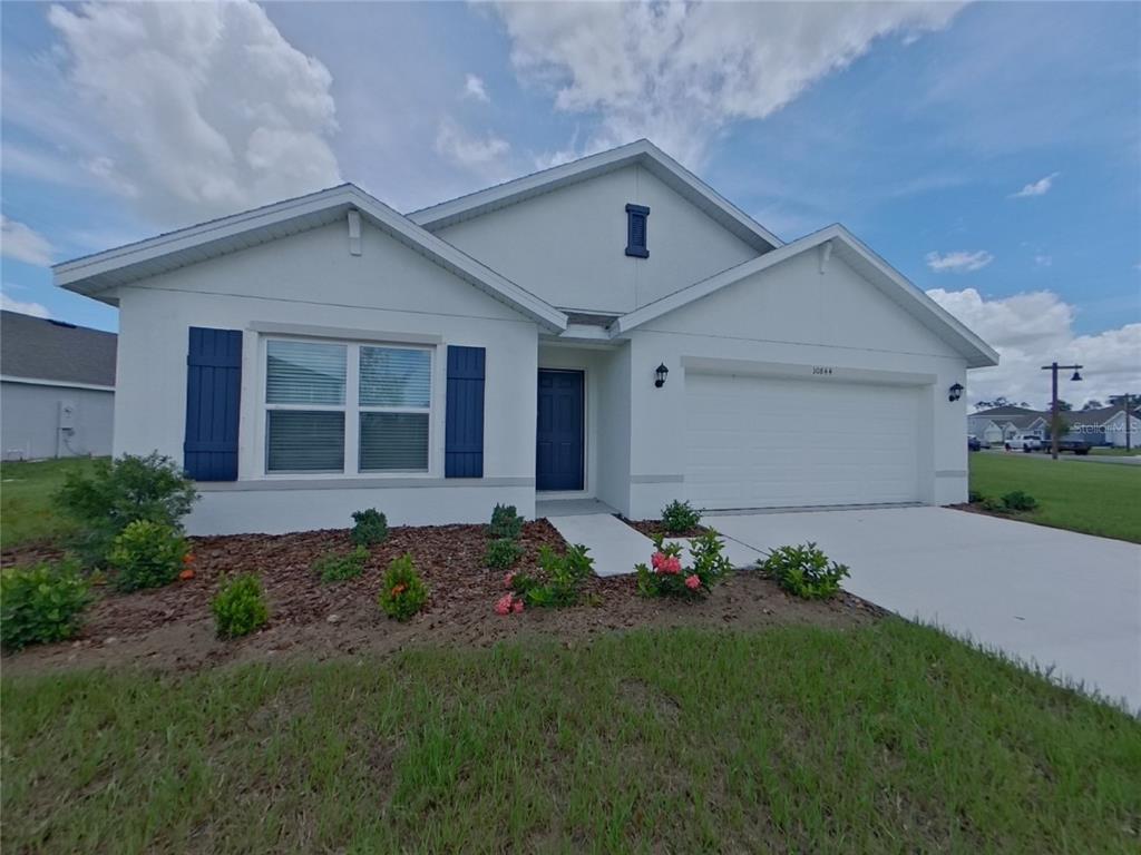 10844 Gentle Current Way Parrish, FL 34219 - Photo 2 of 17 a front view of a house with a garden and plants