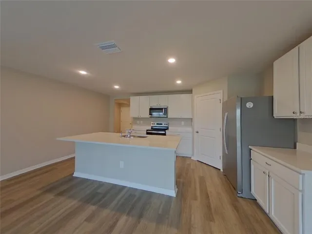 a view of kitchen with sink microwave and refrigerator