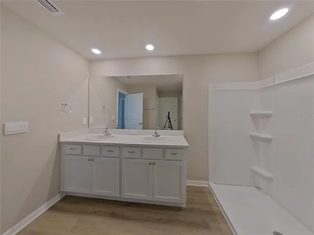 a bathroom with a granite countertop sink a mirror and a bathtub