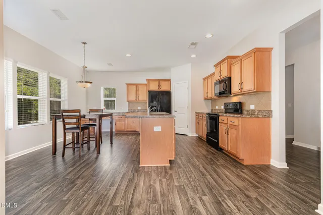 a kitchen with a table chairs refrigerator and microwave