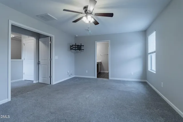a view of empty room with a ceiling fan and window
