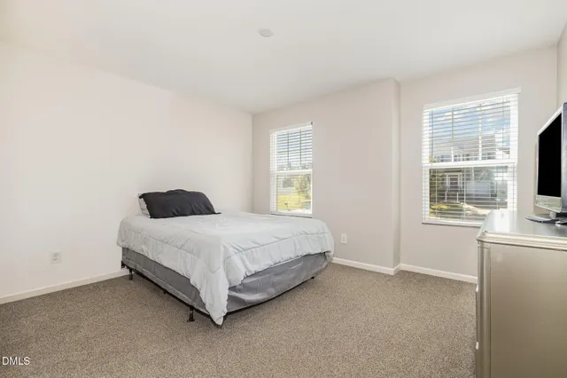a spacious bedroom with a bed and a window