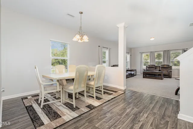 a view of a dining room with furniture and chandelier