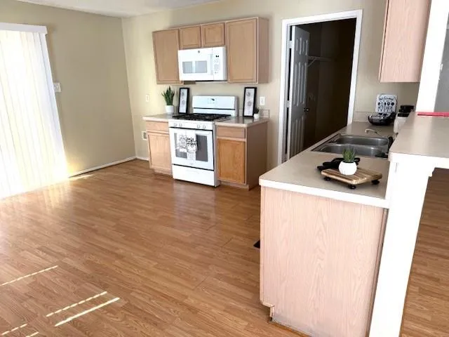 a kitchen with wooden floor white stainless steel appliances and wooden floor