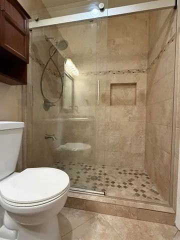 a bathroom with a toilet and a shower