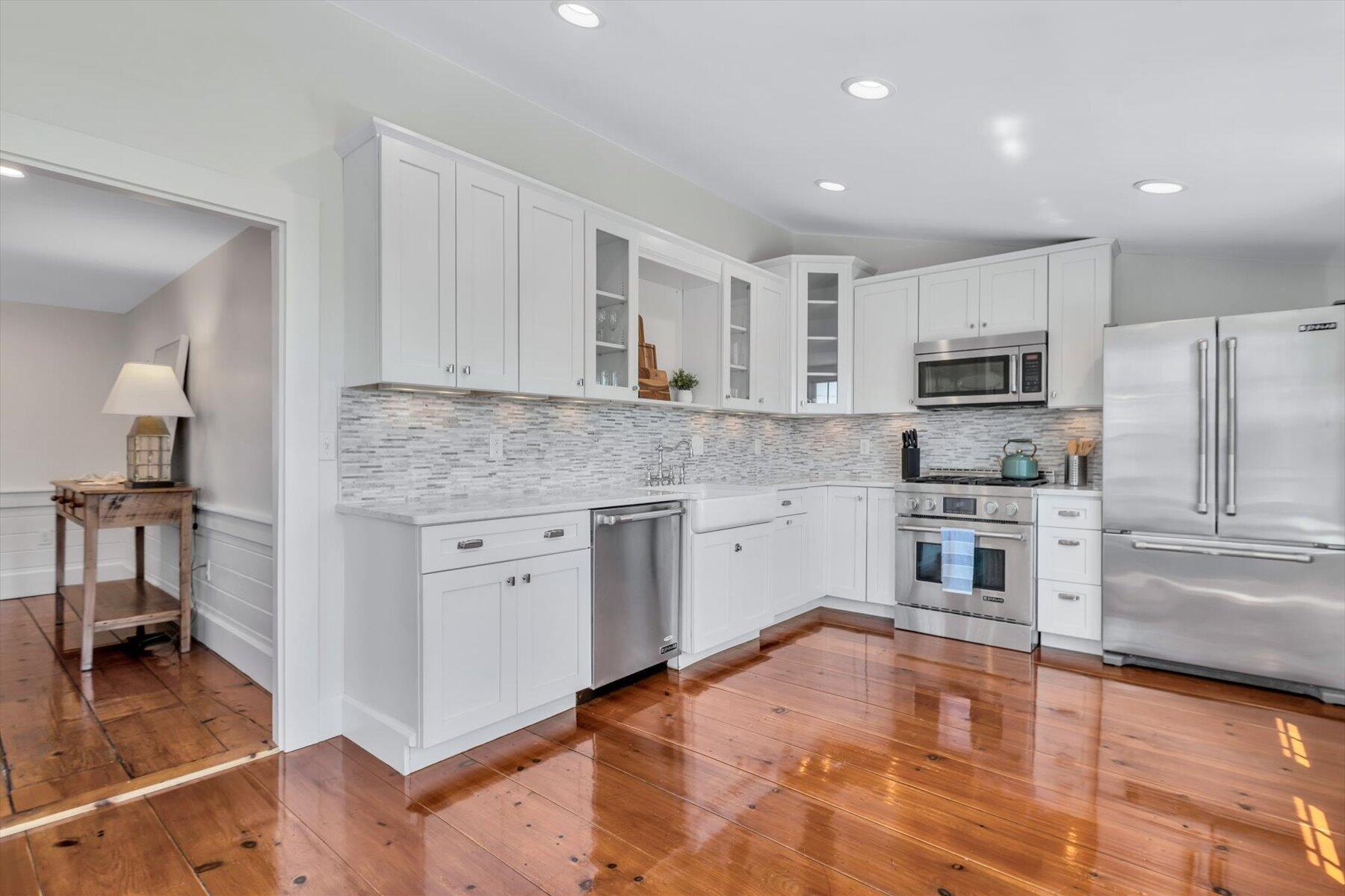 25 Riverside Drive West Harwich, MA 02671 - Photo 13 of 41 a kitchen with stainless steel appliances granite countertop a stove top oven a sink a refrigerator and white cabinets with wooden floor