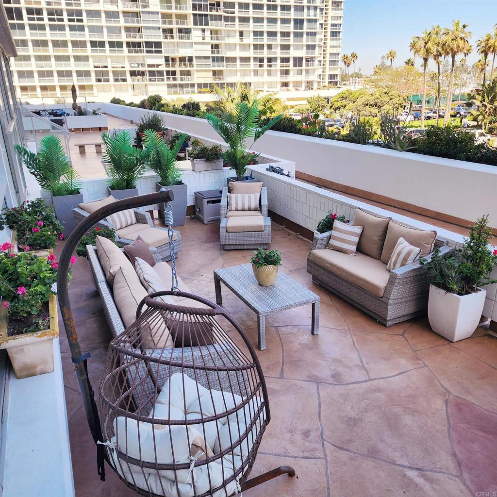 a roof deck with couches and potted plants