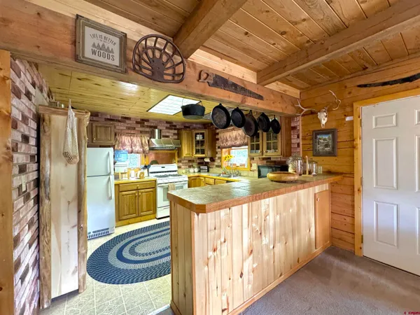 a kitchen that has a lot of white cabinets and stainless steel appliances