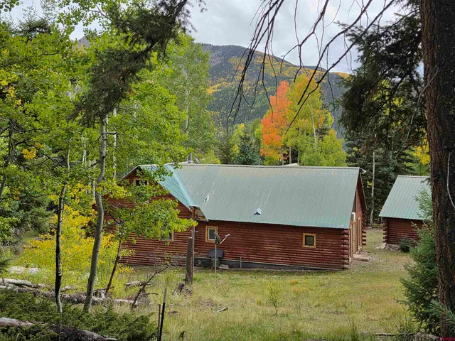 a front view of a house with a garden and trees