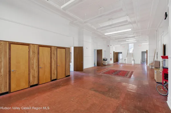 a view of an empty room with furniture and a window