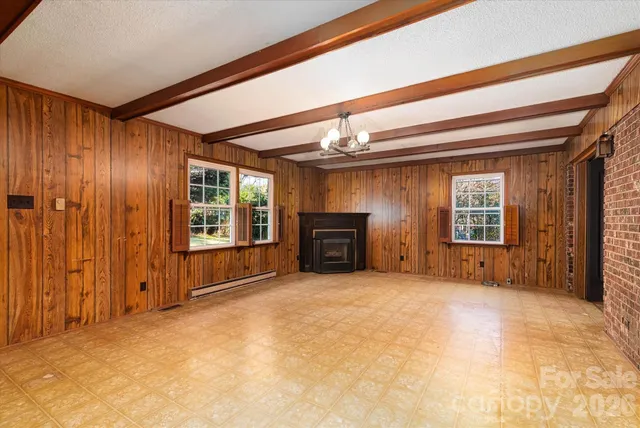 a view of a big room with wooden floor and windows