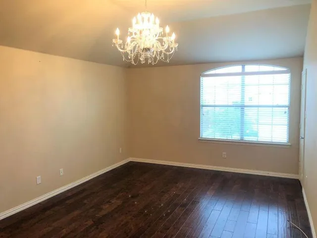 a view of a room with wooden floor and large windows