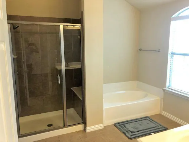 a bathroom with a bathtub and a shower