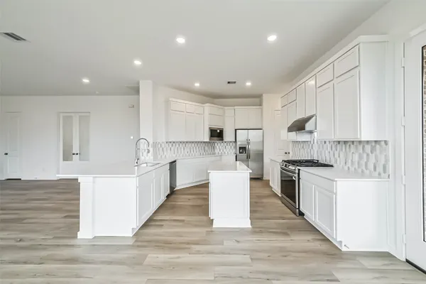 a large kitchen with stainless steel appliances lots of counter top space