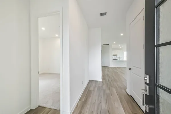 a view of a hallway with wooden floor