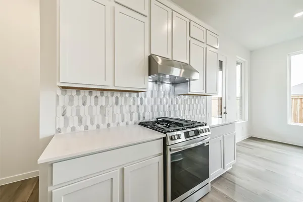 a kitchen with granite countertop a sink stove and cabinets