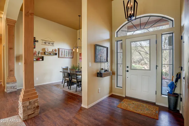 a view of a hallway with wooden floor and a dining room view