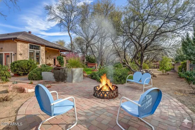 a view of a backyard with furniture and a fire pit