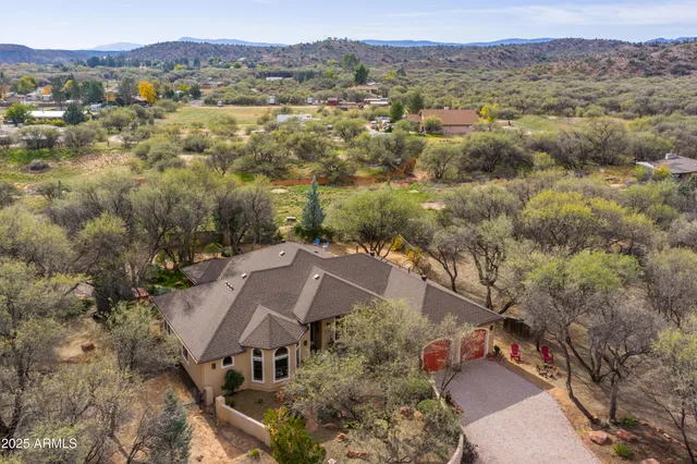 an aerial view of house with yard and mountain view in back