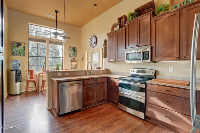 a kitchen with stainless steel appliances granite countertop wooden cabinets and a stove